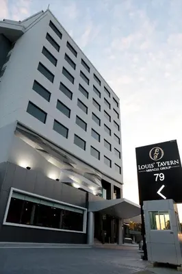 a hotel building with a sign in front of it at Louis Tavern Hotel in Bangkok