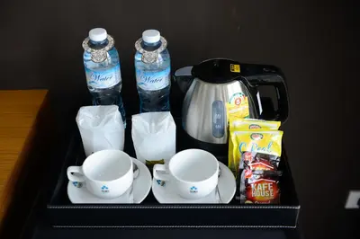 a black tray with cups and teapots and a coffee maker at SiRi Ratchada Bangkok in Bangkok