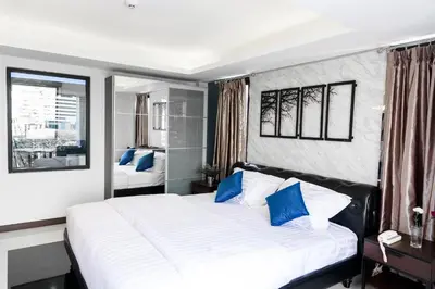 a bedroom with a large white bed with blue pillows at The Connex Asoke in Bangkok