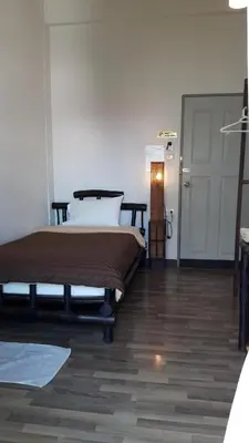 a bedroom with a bed in a room with a door at Lamphuhouse Bangkok in Bangkok