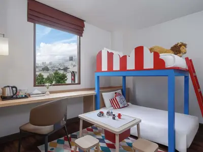 a childs room with a bunk bed and a table at Ibis Bangkok Riverside in Bangkok