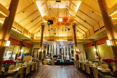 a banquet hall with tables and chairs and a chandelier at Mida Hotel Don Mueang Airport in Bangkok