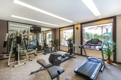 a gym with several treadmills and elliptical machines at Mida Hotel Don Mueang Airport in Bangkok