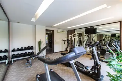 a gym with several treadmills and a row of exercise bikes at Mida Hotel Don Mueang Airport in Bangkok