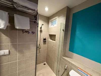 a bathroom with a shower with a glass door at Sawasdee Hotel @ Sukhumvit Soi 8 in Bangkok
