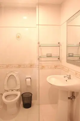 a bathroom with a toilet and a sink at Mirth Sathorn Hotel in Bangkok