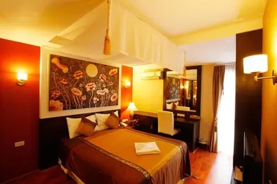 a hotel room with a bed and a painting on the wall at Mirth Sathorn Hotel in Bangkok