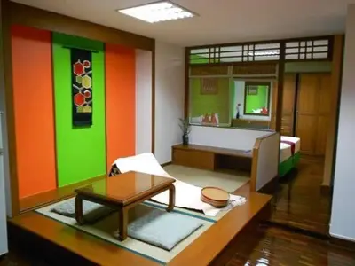 a living room with colorful walls and a room with a table at B.S. Court Hotel Sathorn in Bangkok