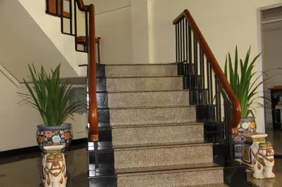 a staircase in a building with two potted plants at B.S. Court Hotel Sathorn in Bangkok