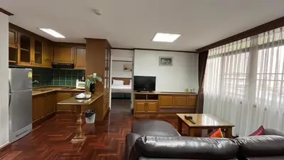 a living room with a couch and a kitchen at Yellow Ribbon Hills Boutique Suites in Bangkok