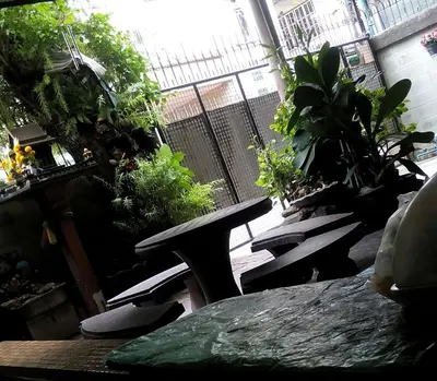 a patio with a bench and a bunch of plants at Anurak Guesthouse in Bangkok