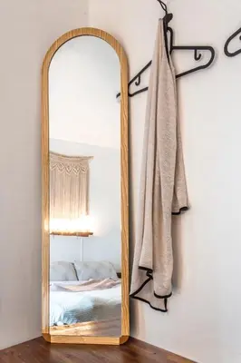 a mirror hanging on a wall next to a bed at Klong House in Bangkok