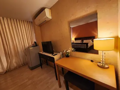 a room with a desk with a computer and a mirror at August Residence in Bangkok