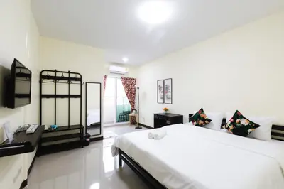 a bedroom with a large white bed and a television at House of Happiness in Bangkok