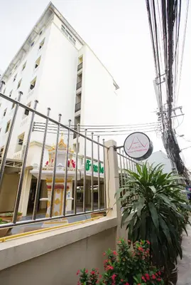 a white building with a fence and a plant at House of Happiness in Bangkok