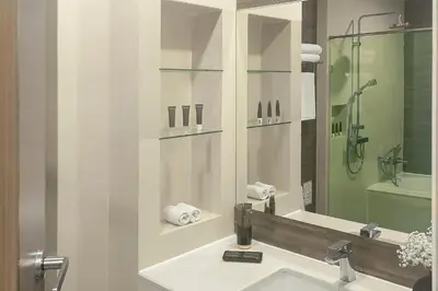 a bathroom with a sink and a mirror at Metropolis Suites Bangkok, Tapestry Collection by Hilton in Bangkok
