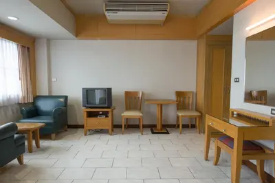 a waiting room with a couch and a tv and chairs at Baan Pratoom in Bangkok