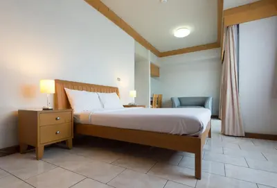 a bedroom with a bed and a desk and a chair at Baan Pratoom in Bangkok