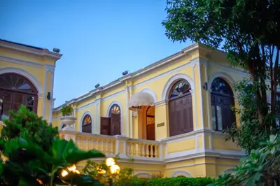 a large yellow building with a balcony at Praya Palazzo in Bangkok