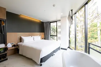 a bedroom with a bed and a large window at STAY Hotel BKK in Bangkok