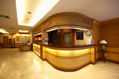 a hotel lobby with a bar in the middle at Wall Street Inn, Bangkok in Bangkok