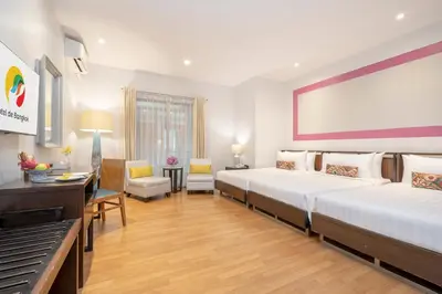 a hotel room with two beds and a desk at Hotel De Bangkok in Bangkok