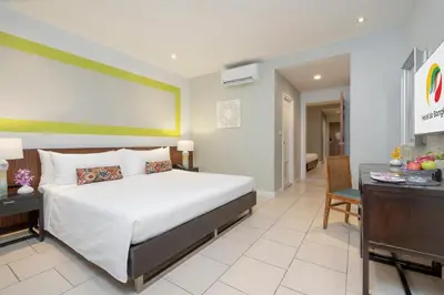 a bedroom with a large bed and a dining room at Hotel De Bangkok in Bangkok
