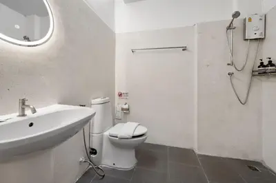 a bathroom with a toilet and a sink and a shower at River View Residence in Bangkok