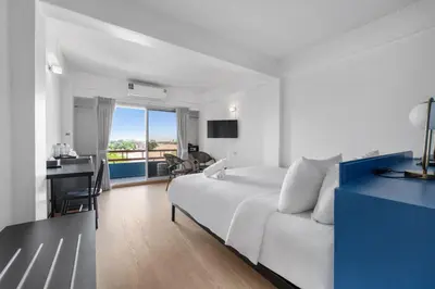 a hotel room with a white bed and a desk at River View Residence in Bangkok