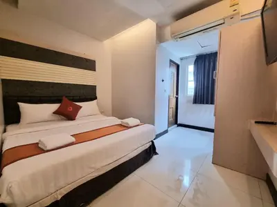 a bedroom with a large bed in a room at Cozi Inn Hotel, Bangkok in Bangkok