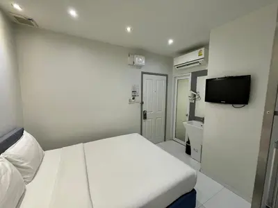 a small room with a bed and a tv at My Hotel Pratunam in Bangkok