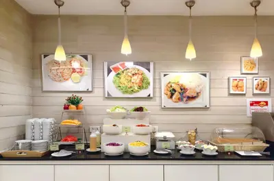 a buffet of food on a counter in a restaurant at My Hotel Pratunam in Bangkok