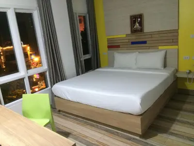 a bedroom with a bed in a room with two windows at For You Residence in Bangkok