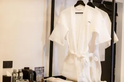 a white shirt is hanging on a rack at Myhotel Cmyk@Ratchada in Bangkok