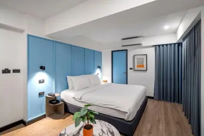 a bedroom with a large bed and blue walls at Myhotel Cmyk@Ratchada in Bangkok