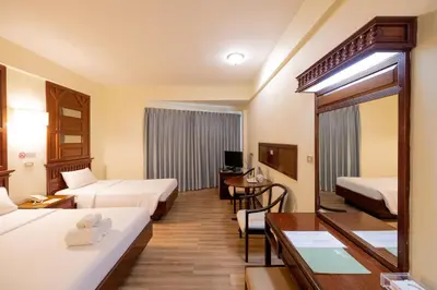 a hotel room with two beds and a desk at MIDO Hotel in Bangkok