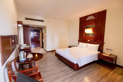 a hotel room with a bed and a television at MIDO Hotel in Bangkok