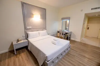 a bedroom with a large white bed and a mirror at MIDO Hotel in Bangkok