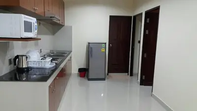 a kitchen with a refrigerator in the middle of a room at The Supara in Bangkok