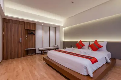 a large bedroom with a large white bed with red pillows at True Siam Phayathai Hotel in Bangkok