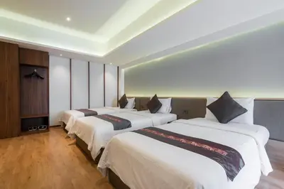 a hotel room with three beds in it at True Siam Phayathai Hotel in Bangkok