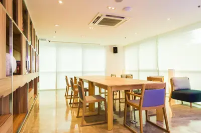 a dining room with a wooden table and chairs at ZAZZ Urban Bangkok in Bangkok