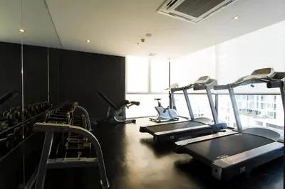 a gym with several tread machines in a room at ZAZZ Urban Bangkok in Bangkok