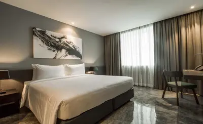 a hotel room with a large bed and a desk at ZAZZ Urban Bangkok in Bangkok