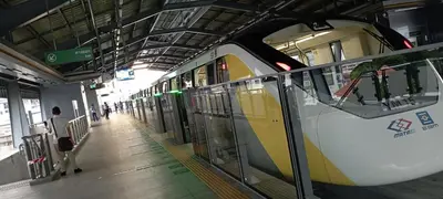 a subway train in a station with a person standing next to it at SKB Mansion close to MRT in Hua mark in Bangkok