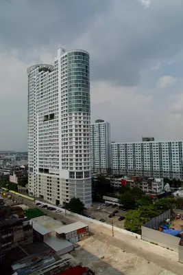 a tall white building in a city with buildings at SKB Mansion close to MRT in Hua mark in Bangkok