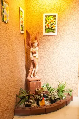 a statue of an angel with plants in a room at Thaiphiphat house in Bangkok