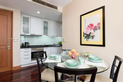 a kitchen with a dining room table with chairs at Sky Villas Apartments in Bangkok
