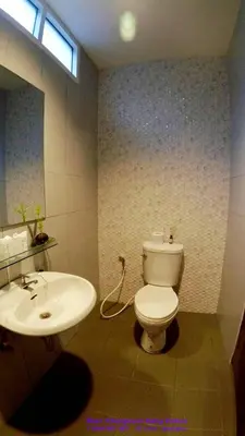 a bathroom with a white toilet and a sink at Baan Glangsuan Bang Kobua in Bang Chak