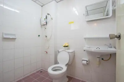 a bathroom with a toilet and a sink at Goody Hotel in Bangkok